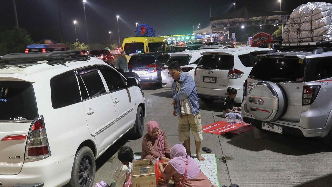 Sejumlah pemudik menggelar tikar saat menikmati makan sahur di dekat Gerbang Tol Cikampek Utama, Cikampek, Jawa Barat, Sabtu (6/4/2024). Arus mudik Lebaran 2024 telah dimulai. Berbagai pemandangan menarik terekam dalam perjalanan warga ketika menuju ke ka