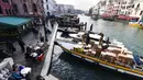 Sebuah kapal yang mengangkut barang berlabuh di dermaga Grand Canal di Venesia (4/11/2019). Kanal ini merupakan salah satu koridor lalu lintas air utama di Venesia. (AFP Photo/Miguel Medina)