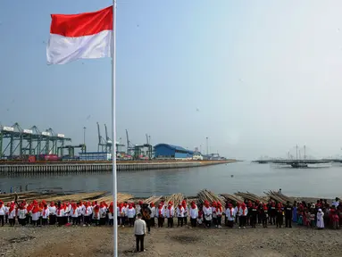 Warga pesisir pantai Cilncing melakukan upacara bendera HUT ke-74 Ri di pinggir pantai, RW 04, Cilincing, Jakarta Utara, Sabtu (17/8/2019). Kegiatan yang diikuti warga RW 08 Manunggal ini diprakarsai Kelas Jurnalistik Cilik dalam rangka memupuk  rasa kebangsaan. (merdeka.com/Arie Basuki)