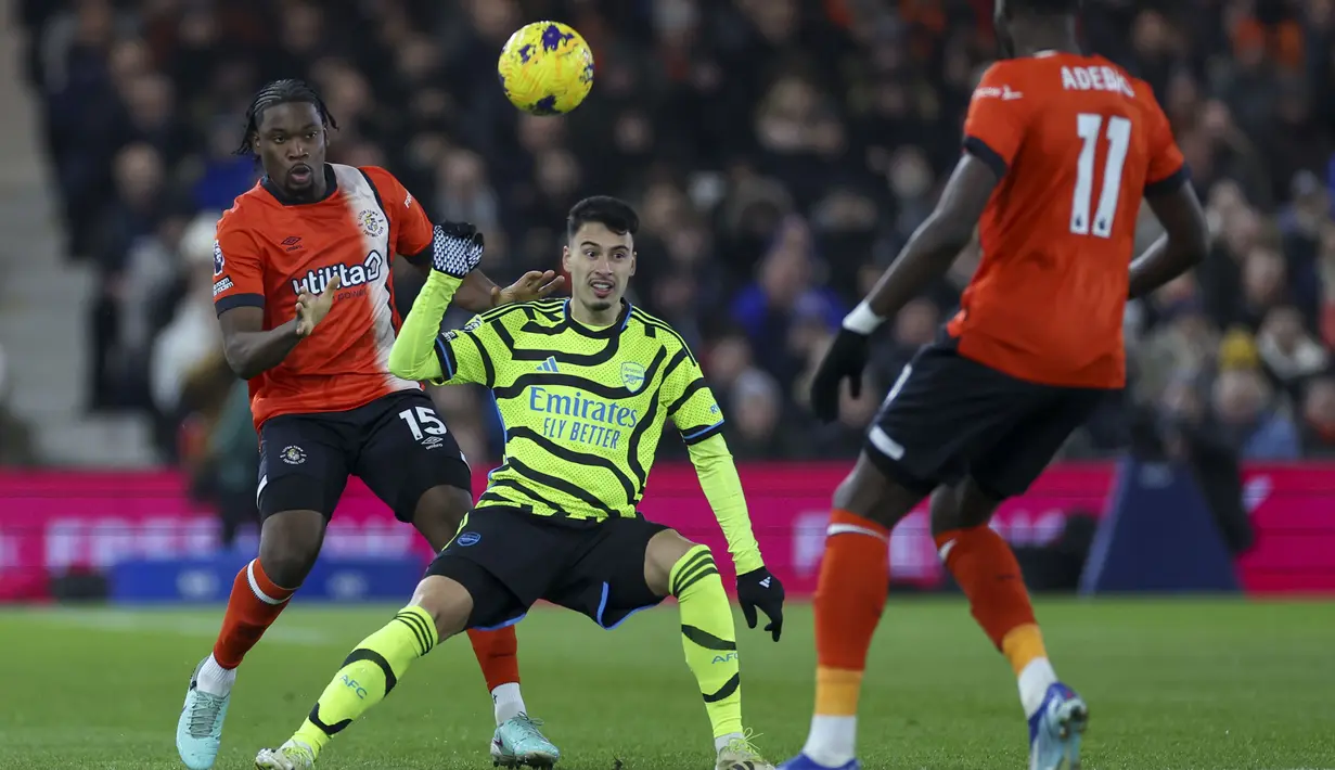 Gelandang Arsenal, Gabriel Martinelli (tengah) berebut bola dengan bek Luton Town, Teden Mengi pada laga lanjutan pekan ke-15 Liga Inggris 2023/2024 di Kenilworth Road, Luton, Rabu (6/12/2023) dini hari WIB. (AP Photo/Ian Walton)