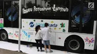 Sejumlah anak berkebutuhan khusus melukis bus Transjakarta di halaman Balai Kota, Jakarta, Jumat (20/4). Kegiatan tersebut dalam rangka memperingati Hari Kartini. Tema lukisan yang diangkat adalah ‘Ibuku Perempuan Tangguh’. (Liputan6.com/Arya Manggala)