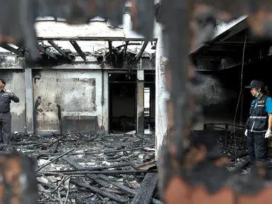 Ahli forensik memeriksa bangunan asrama sekolah khusus anak perempuan dari keluarga suku pedalaman miskin yang terbakar di Thailand utara, Senin (23/5). Setidaknya 17 anak perempuan tewas dalam kebakaran tersebut. (REUTERS/Athit Perawongmetha)
