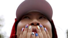 Warga tampak kagum menyaksikan acara pembukaan Olimpiade 2024 di Paris, Sabtu (27/7/2024). (AP Photo/Louise Delmotte)