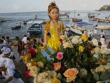 Sebuah boneka besar yang mewakili Dewi Laut Yemanja dibawa menuju ke laut dari pantai Pantai Red River di Salvador, Brasil (2/2). Dalam kepercayaan Afro-Brasil, Yemanja diyakini sebagai representasi dewi laut yang cantik jelita. (AP Photo / Eraldo Peres)