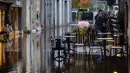 Suasana lokasi pertokoan yang tergenang banjir. (Fred TANNEAU/AFP)