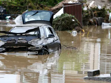 Puing-puing dan sebuah mobil yang rusak akibat banjir di desa Bavarian, Munich , Jerman , 2 Juni 2016. Petugas menemukan 3 wanita  yang tewas diruang bawah tanah rumah yang terendam banjir dan 1 tewas akibat tenggelam di sungai. (REUTERS / Michaela Rehle)