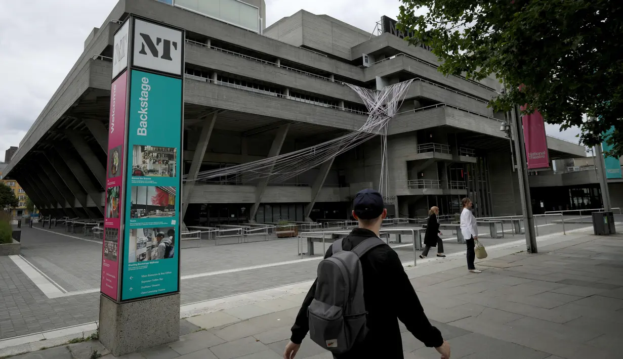 Pria berjalan melewati gedung National Theater yang disegel, London, Inggris, Selasa (7/7/2020). Pemerintah Inggris akan menyalurkan paket bantuan sebesar 1,57 miliar poundsterling kepada industri seni, budaya, dan warisan untuk membantu mengatasi dampak pandemi COVID-19. (Xinhua/Tim Ireland)