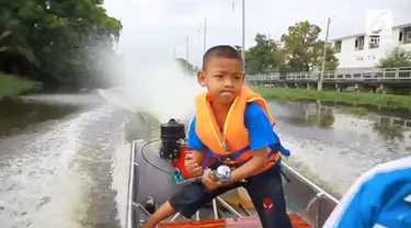 Bocah berusia 5 tahun mengemudikan motor boat ke sekolah. Motor boat menjadi alat transportasi utama di tempat tinggalnya di pinggiran Bangkok.