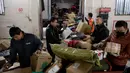 Para pekerja ekspedisi sibuk memilah paket untuk dikirim ke pelanggan saat Singles Day di Beijing, China, Senin (11/11/2019). Singles Day menjadi pesta belanja online terbesar di dunia. (NOEL CELIS/AFP)