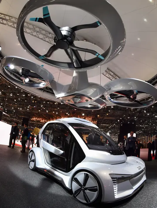 Pengunjung mencoba mobil Pop.up next" keluaran Audi yang  dipamerkan dalam Geneva International Motor Show di Jenewa (6/3). Agar bisa terbang, mobil ini memiliki empat polong yang menampung delapan baling-baling helikopter. (AFP Photo/Fabrice Coffrini)