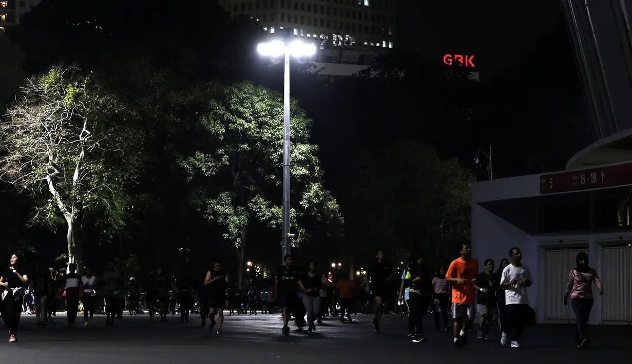Sejumlah warga berlari di kawasan Stadion Utama Gelora Bung Karno, Senayan, Jakarta, Rabu (9/10). Olahraga lari pada malam hari di GBK menjadi pilihan pekerja ibu kota. (Bola.com/Yoppy Renato)