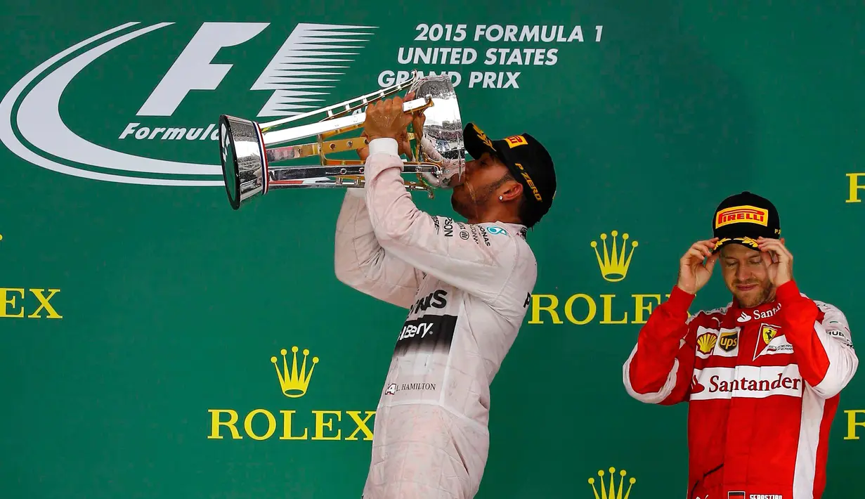 Pembalap Mercedes, Lewis Hamilton meminum sampanye usai memenangkan GP F1 Amerika Serikat di Sirkuit The Americas, Minggu (25/10). Ini merupakan gelar juara dunia ketiga bagi Hamilton setelah sebelumnya diraih pada 2008 dan 2014. (REUTERS/ Mike Stone)