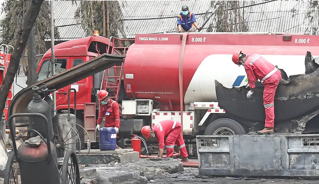Petugas Pertamina menyedot sisa isi bahan bakar pada truk tangki yang terbakar di SPBU Jalan Kahfi 2, Jagakarsa, Jakarta, Sabtu (30/12). Pada saat terbakar, truk tangki diketahui memuat bahan bakar jenis pertalite. (Liputan6.com/Herman Zakharia)