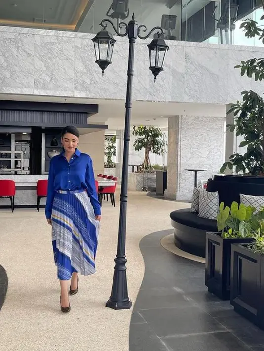 Tampil serba biru, pesinetron 31 tahun ini terlihat memadukan kemeja satin dengan rok plisket asimetris warna putih dan biru.  (Instagram/tsaniamarwa54).