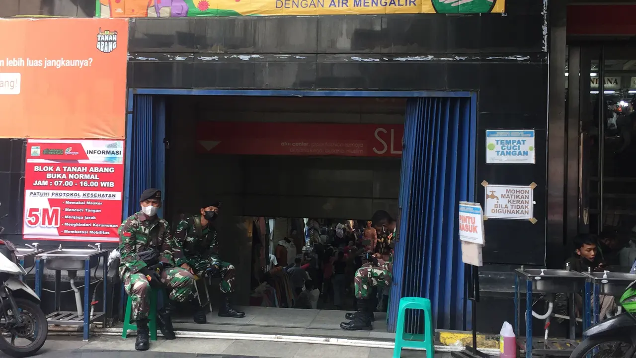 Sejumlah personel TNI berjaga di salah satu pintu masuk Pasar Tanah Abang Blok A. (Liputan6.com/M Radityo Priyasmoro)