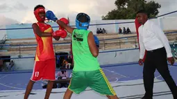 Petinju Somalia bertanding di atas ring di Stadion Wish, Mogadishu pada 15 November 2018. Pertandingan setelah Somalia pulih dari perang saudara itu digelar di lapangan basket yang disulap menjadi area pertarungan. (Abdirazak Hussein FARAH / AFP)