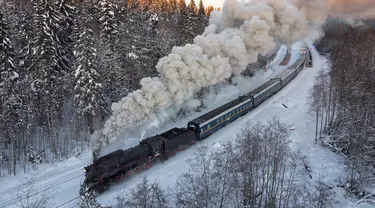 Sebuah lokomotif uap era Soviet menarik kereta retro di taman alam Ruskeala, sekitar 200 km (125 mil) di utara St. Petersburg, Rusia (17/2/2021). Kereta retro bertenaga uap tersebut beroperasi setiap hari di perbatasan Rusia dengan Karelia. (AP Photo/Dmitri Lovetsky)