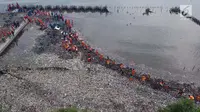 Petugas Suku Dinas Lingkungan Hidup membersihkan lautan sampah di Kawasan Hutan Mangrove Ecomarine Muara Angke, Jakarta, Minggu (18/3). Total ada 19,34 ton sampah diangkut pada pembersihan yang dilakukan sejak Sabtu (17/3). (Liputan6.com/Arya Manggala)