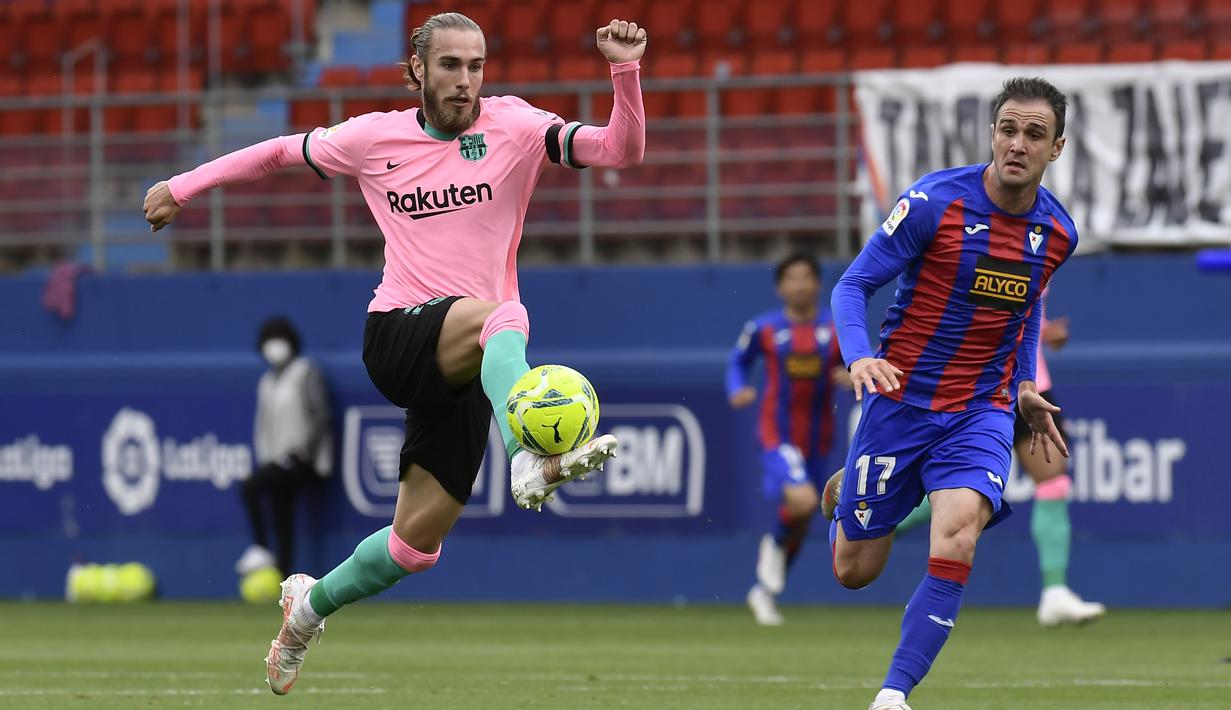 Pemain Barcelona, Oscar Mingueza, mengontrol bola saat melawan Eibar pada laga Liga Spanyol di Stadion Ipurua, Sabtu (23/5/2021). Barcelona menang dengan skor 1-0. (AP/Alvaro Barrientos)