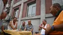 Sekelompok pria tertawa saat bermain kartu remi di trotoar di luar gedung apartemen di Beijing, China (10/8). Ada 1001 macam permainan kartu. Setiap negara, bahkan wilayah suatu negara, memiliki jenis permainannya sendiri. (AFP Photo/Greg Baker)