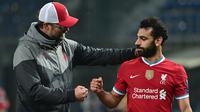 Pelatih Liverpool, Jurgen Klopp, memberikan selamat kepada Mohamed Salah usai timnya meraih kemenangan atas Atalanta pada laga lanjutan Liga Champions 2020/2021 di Gewiss Stadium, Rabu (4/11/2020) dini hari WIB. Liverpool menang 5-0 atas Atalanta. (AFP/Miguel Medina)