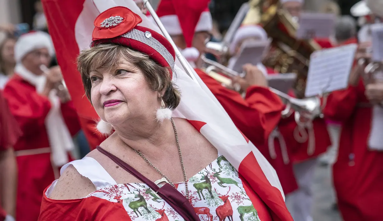 Seorang wanita saat mengikuti parade Kongres Dunia Sinterklas  tahunan di Kopenhagen, Denmark (22/7/2019). Kongres pertemuan sinterklas sudah diadakan sejak tahun1957. (AP Photo/Liselotte Sabroe/Scanpix 2019)
