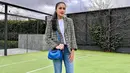 Padu padan blazer ala Sandra Dewi tidak pernah terlihat membosankan. Kali ini atasan kaus putih ditumpuknya dengan tweed blazer bernuansa kehijauan, dipadu dengan celana jeans, sling bag biru, dan sneakers putih. Foto: Instagram.