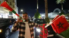 Seorang pria Maroko meniup vuvuzela sambil menjual bendera nasional di Rabat selama perayaan setelah kemenangan tim mereka di final Piala Arab 2025 antara Yordania dan Maroko yang berlangsung di Stadion Lusail, Lusail pada 18 Desember 2025. (Abdel Majid BZIOUAT/AFP)