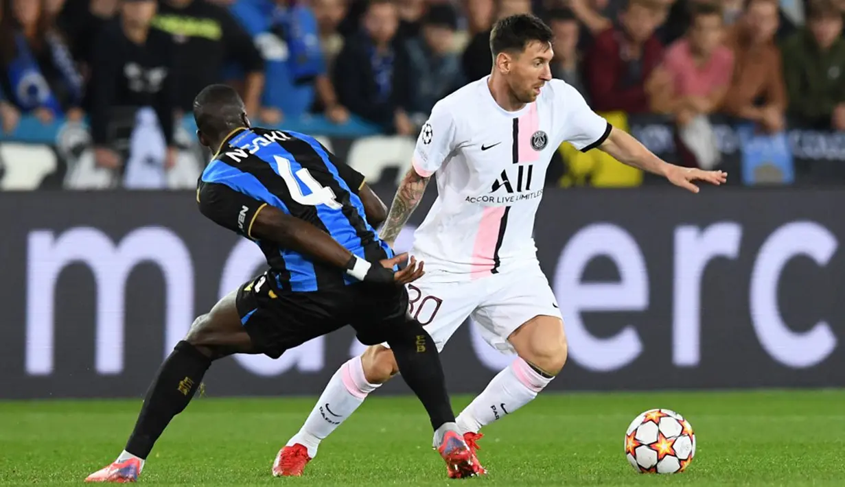 Pemain Paris Saint-Germain Lionel Messi berebut bola dengan pemain Club Brugge Stanley Nsoki pada pertandingan Grup A Liga Champions di Stadion Jan Breydel, Bruges, Belgia, Rabu (15/9/2021). Pertandingan berakhir imbang 1-1. (JOHN THYS/AFP)