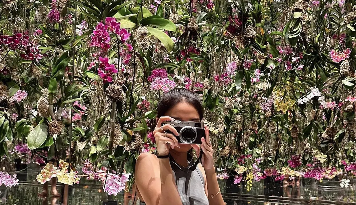 Ia tampil kasual mengenakan sleeveless cropped top warna abu-abu dan dipadukan high waisted jeans.  [@azizahsalsha_]