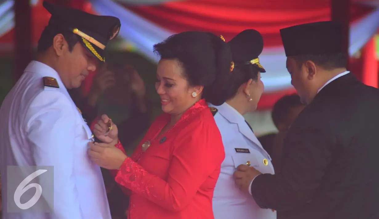 Walikota Semarang Hendar Prihadi saat dipasangkan lencana oleh Istrinya saat mengikuti pelantikan di Lapangan Simpanglima Semarang , Rabu (17/2). Sebanyak 17  pasangan kepala daerah dilantik untuk periode 2016-2021. (Liputan6.com/Gholib)