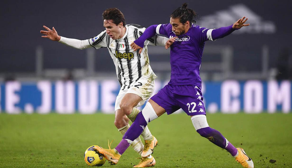 Penyerang Juventus, Federico Chiesa, berebut bola dengan pemain Fiorentina, Martín Caceres, pada laga Liga Italia di Turin, Rabu (23/12/2020). Fiorentina menang dengan skor 0-3. (Fabio Ferrari/LaPresse via AP)