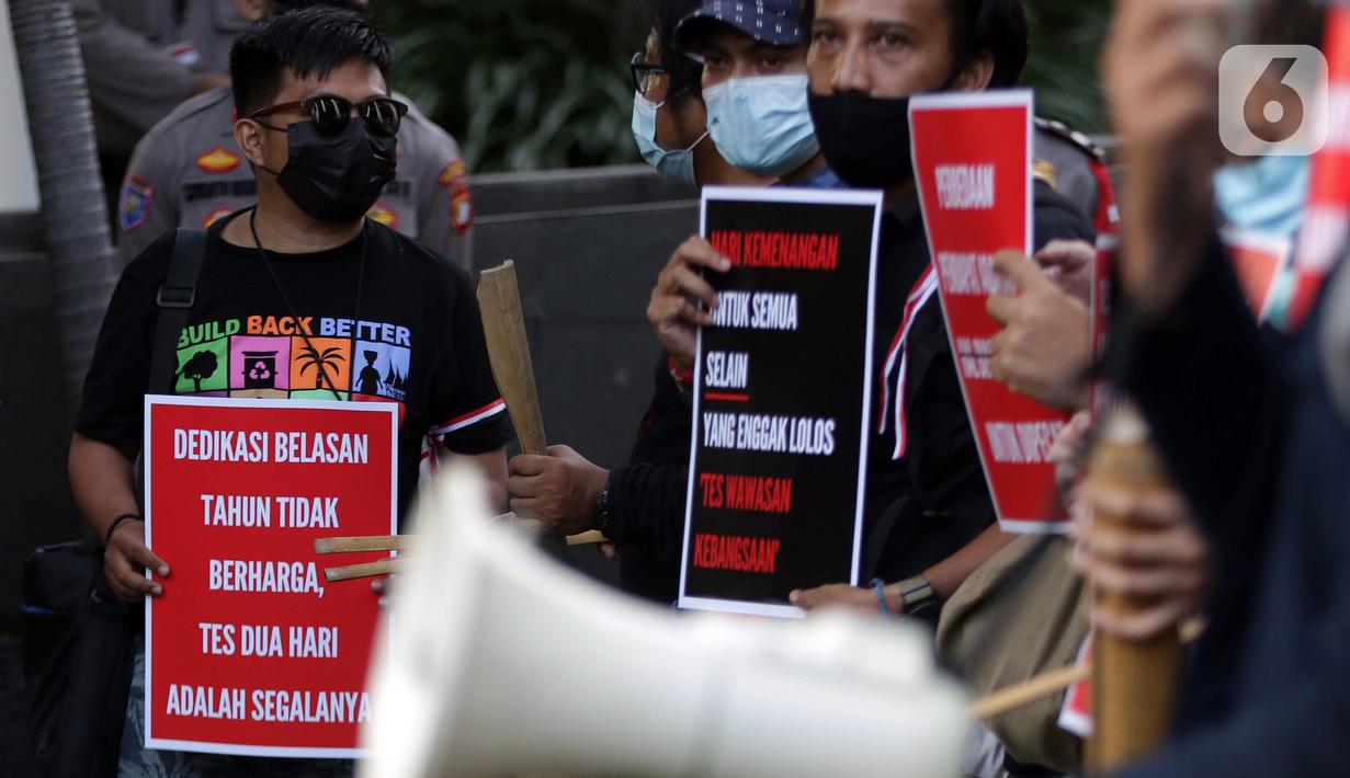 Peserta aksi dari Koalisi Masyarakat Sipil AntiKorupsi membawa poster saat berunjukrasa di depan Gedung KPK Jakarta, Selasa (18/5/2021). Dalam aksinya, sambil membunyikan kentongan mereka memberi dukungan kepada 75 pegawai KPK yang dinyatakan tidak lulus TWK. (Liputan6.com/Helmi Fithriansyah)
