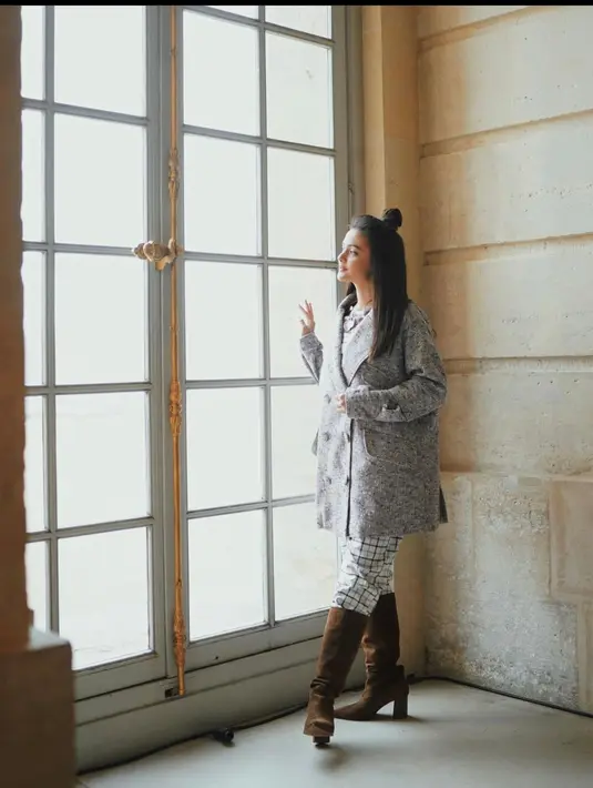 Coat motif berwarna abu-abu sangat serasi apabila dipasangkan dengan celana tartan putih dan heels boots berwarna coklat, lho. Sangat cocok untuk oufitmu ketika menghadiri Paris Fashion Week. (instagram/amandarawles)