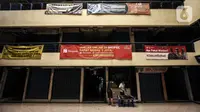 Dua orang pria beraktivitas di Pasar Cipulir, Jakarta, Rabu (7/7/2021). Pemberlakuan Pembatasan Kegiatan Masyarakat (PPKM) Darurat pada tanggal 3 sampai 20 Juli 2021 untuk menekan penyebaran COVID-19 berdampak pada ditutupnya Pasar Cipulir. (Liputan6.com/Johan Tallo)