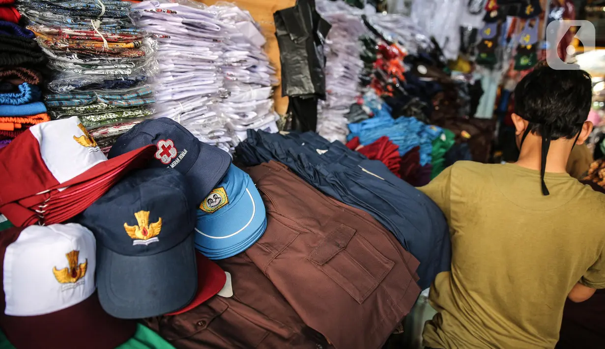 Penjual seragam sekolah menunggu pembeli di kawasan Pasar Jatinegara, Jakarta, Selasa (30/6/2020). Sejumlah pedagang di tempat itu mengeluhkan omset penjualan seragam sekolah yang menurun hingga 90 persen akibat sepi pembeli dan anjuran belajar di rumah saat  COVID-19. (Liputan6.com/Faizal Fanani)