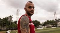 Bek Bali United, Kiko Insa, menunjukan tato bergambar singa dengan tulisan salam satu jiwa yang merupakan identitas Arema, usai latihan di Lapangan Pertamina, Simprug, Jakarta, Rabu (6/4/2016). (Bola.com/Vitalis Yogi Trisna)