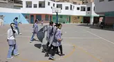 Siswi-siswi sekolah Palestina berjalan-jalan di taman bermain sekolah yang dikelola Badan PBB untuk pengungsi Palestina (UNRWA) di kamp pengungsi Shuafat, Yerusalem timur pada 6 Mei 2025. (AHMAD GHARABLI/AFP)