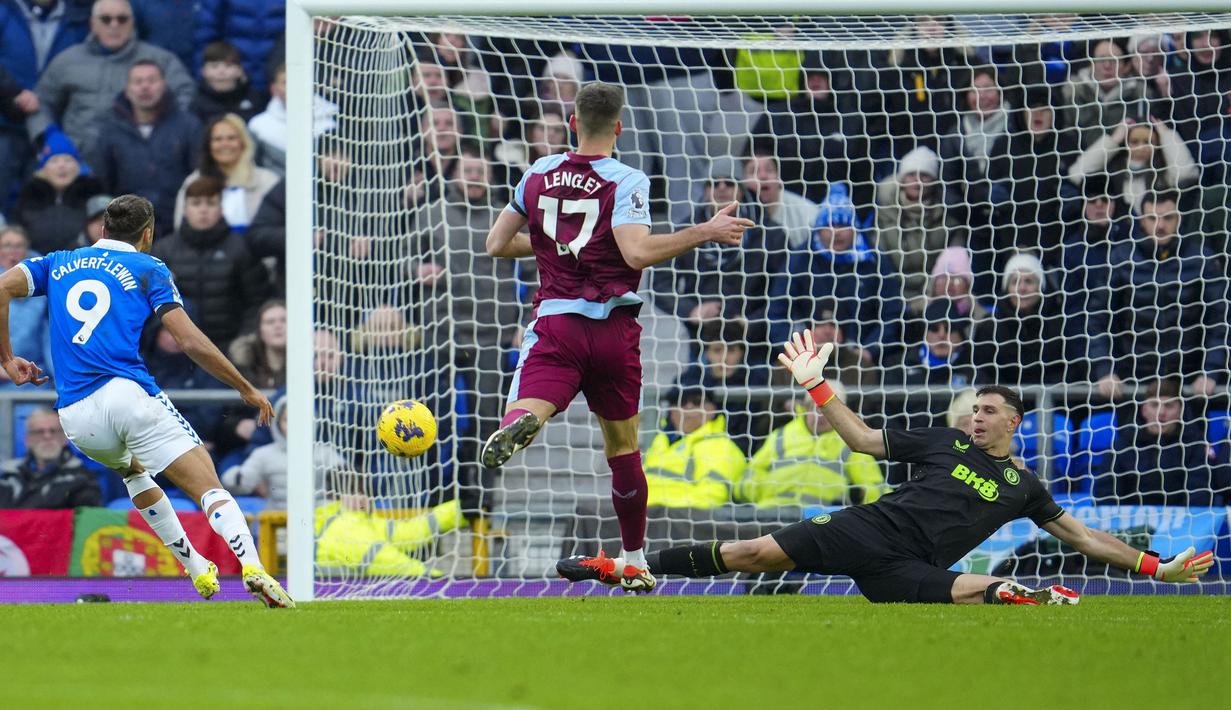 Kiper Aston Villa, Emiliano Martinez (kanan) menghalau tendangan dari pemain Everton, Dominic Calvert-Lewin pada laga lanjutan Liga Inggris 2023/2024 di Goodison Park, Liverpool, Inggris, Minggu (14/01/2024) malam WIB. (AP Photo/Jon Super)