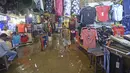 Seorang lelaki berjalan melalui pusat perbelanjaan yang digenangi air di Dhaka (21/7/2020). Korban tewas akibat hujan lebat di Asia Selatan meningkat menjadi hampir 200, ketika Bangladesh dan Nepal memperingatkan bahwa naiknya air akan membawa banjir lebih lanjut. (AFP/Munir Uz zaman)