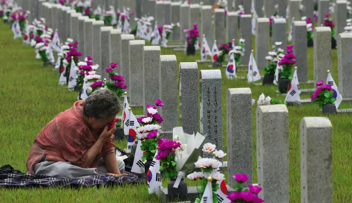 Seorang wanita Korsel menyeka air matanya saat mengunjungi makam kerabat yang gugur untuk negara pada Memorial Day di Pemakaman Nasional Seoul, Kamis (6/6/2019). Memorial Day didedikasikan untuk mengingat prajurit dan warga sipil yang gugur selama perang Korea antara 1950-1953. (Jung Yeon-je/AFP)