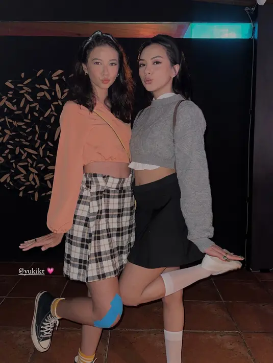 Yuki Kato tampil rebel dengan crop puffy long sleeve oranye dan rok mini kotak-kotak. Perban biru dan sneakers bikin Yuki terlihat lebih boyish [@nazlaalifa]