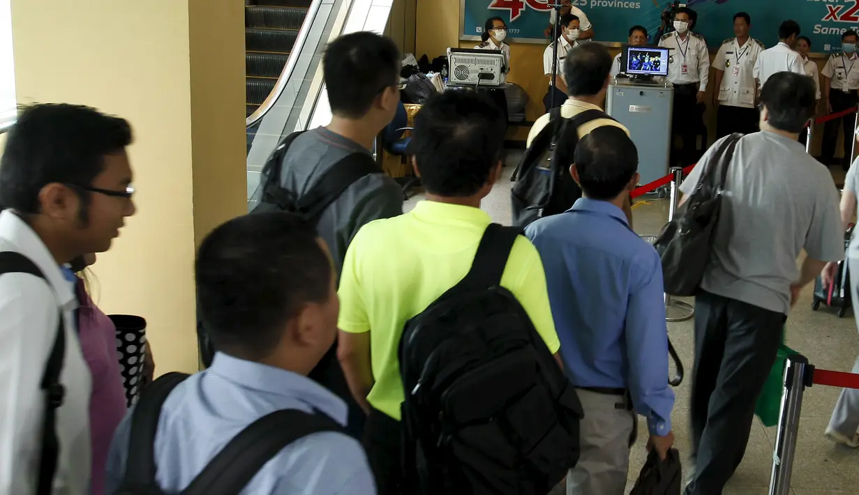 Para penumpang melewati alat pemindai suhu tubuh ketika tiba di Bandara Internasional Phnom Penh, Kamboja, Selasa (23/6/2015). Pemerintah Kamboja meningkatkan pemeriksaan kesehatan untuk mencegah penyebaran MERS. (REUTERS/Samrang Pring) 