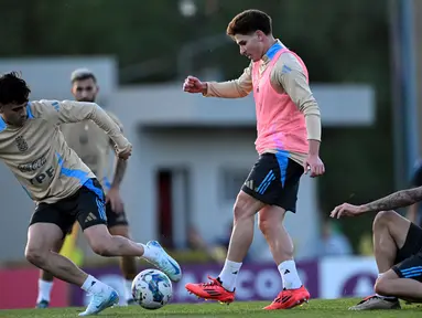 Pemain tengah tim nasional Argentina, Facundo Buonanotte (kanan) berebut bola dengan Julian Alvarez (tengah) saat sesi latihan di Ezeiza, provinsi Buenos Aires, pada 12 November 2024. (LUIS ROBAYO/AFP)