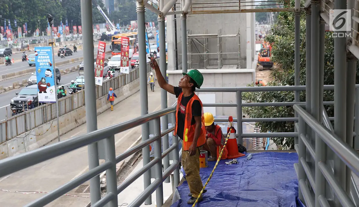 Pekerja mengecat jembatan penyeberangan orang di kawasan Senayan, Jakarta, Jumat (6/7). Pengecatan tersebut merupakan bagian dari proyek revitalisasi JPO guna meningkatnya kenyamanan pejalan kaki. (Liputan6.com/Immanuel Antonius)