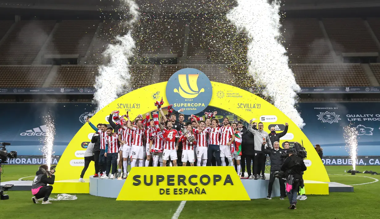 Para pemain Athletic Bilbao mengangkat trofi Piala Super Spanyol usai pertandingan final melawan Barcelona di stadion La Cartuja di Seville, Senin (18/1/2021). Lionel Messi dkk. kalah 2-3 dari Athletic Bilbao pada laga final Piala Super Spanyol. (AFP/RFEF/Pablo Garcia)