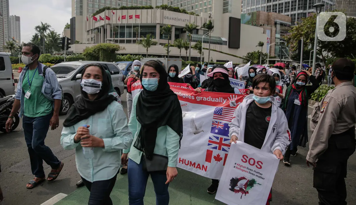 Ratusan imigran Afghanistan jalan kaki menuju Kedubes Kanada di Jakarta, Senin (13/12/2021). Dengan membawa spanduk dan poster, mereka menuntut UNHCR dan IOM segera memproses penempatan mereka ke negara tujuan seperti Kanada, Australia, Selandia Baru maupun AS. (Liputan6.com/Faizal Fanani)