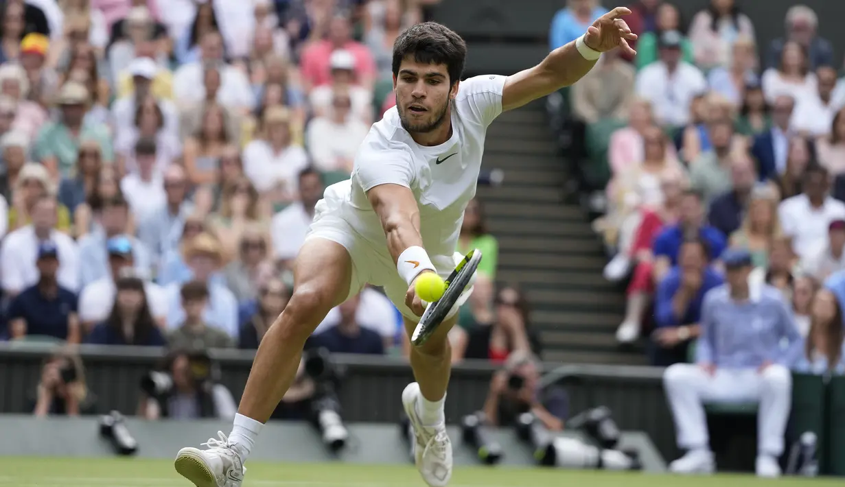 Petenis Spanyol, Carlos Alcaraz berusaha mengembalikan bola saat menghadapi petenis Serbia, Novak Djokovic pada laga final tunggal putra turnamen tenis Grand Slam Wimbledon 2023 di All England Lawn and Tennis Club, London, Minggu (16/7/2023) malam WIB. (AP Photo/Kirsty Wigglesworth)