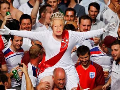 Suporter Inggris bergaya ala Ratu Elizabeth II saat mendukung timnya melawan Slovakia dalam laga terakhir Grup B Piala Eropa di di Stade Geoffroy-Guichard, Saint-Etienne, Selasa (21/6/2016) dini hari WIB. (Reuters/Wolfgang Rattay)