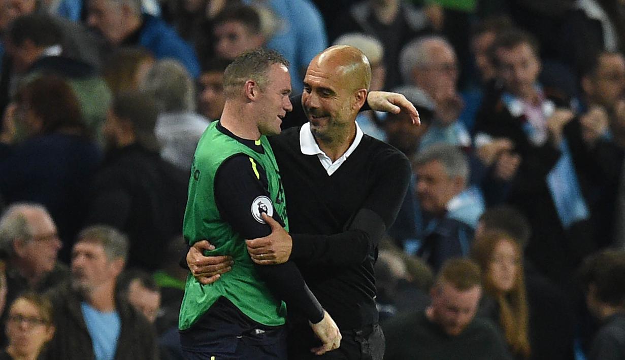 Striker Everton, Wayne Rooney, berbincang dengan pelatih Manchester City, Pep Guardiola, pada laga Premier League di Stadion Etihad, Selasa (22/8/2017). Wayne Rooney berhasil mencetak gol ke 200 di ajang Premier League. (AFP/Oli Scarff)